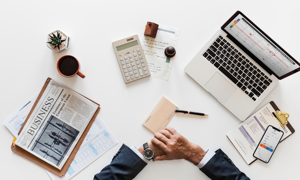 man in front of laptop, calculator, and papers