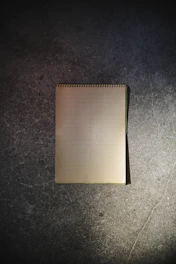 A sleek, dark-themed workbook open on a desk with gold-accented typography.