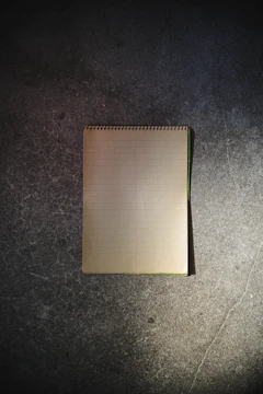 A sleek, dark-themed workbook open on a desk with gold-accented typography.