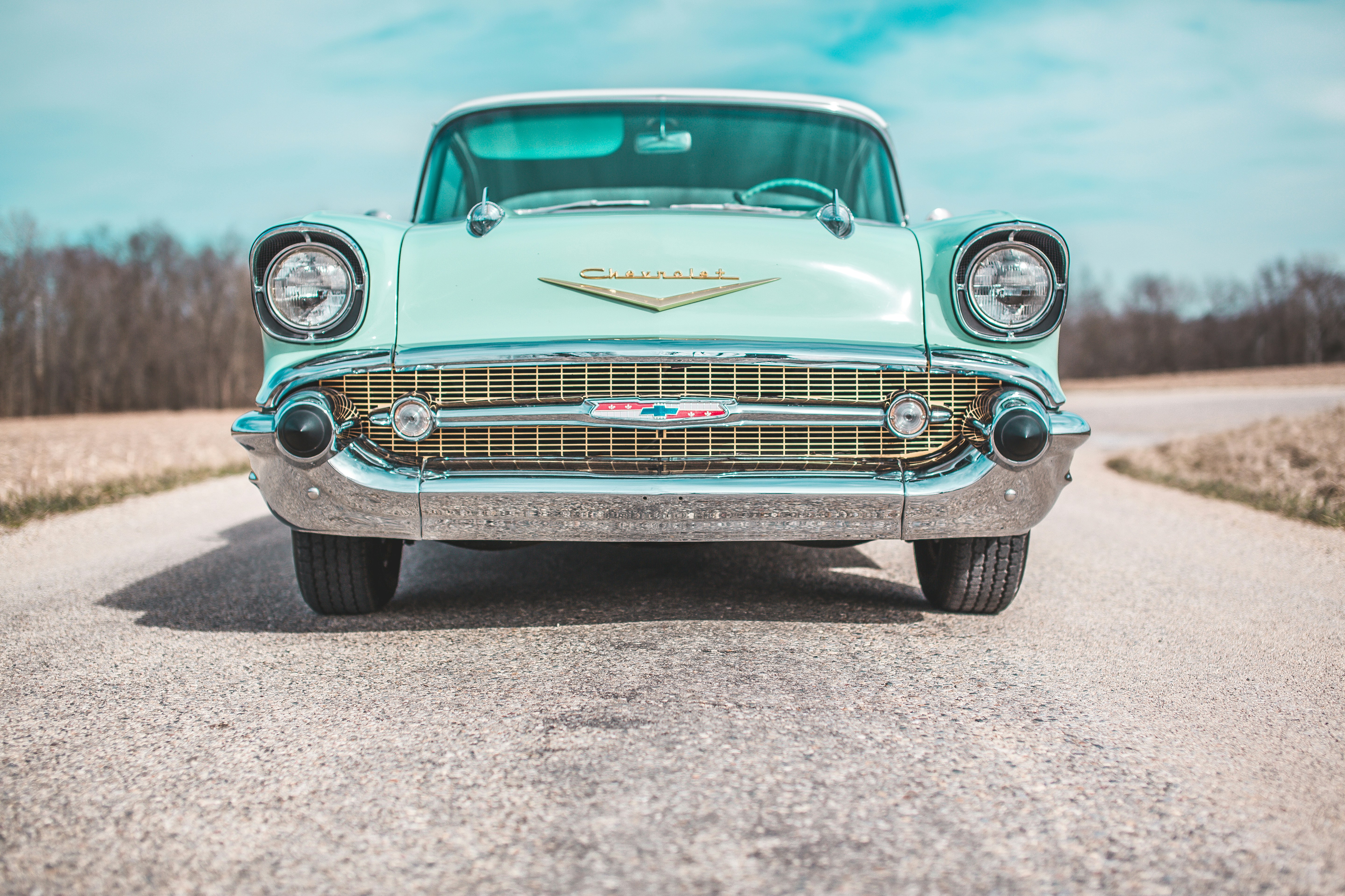 low-angle photo of classic teal Chevrolet car