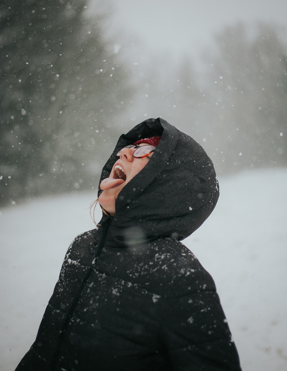 person opening his mouth to taste the snow