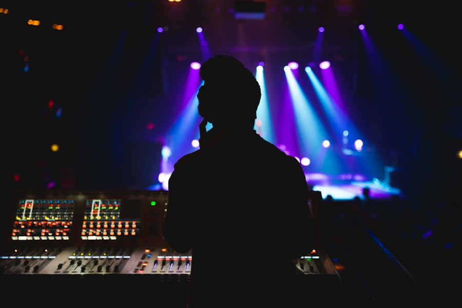 Silhouette d'un DJ à la régie, jeux de lumière violets