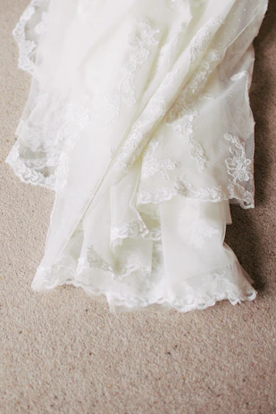 Delicate lace trims laid out on a wooden table, emphasizing intricate patterns.