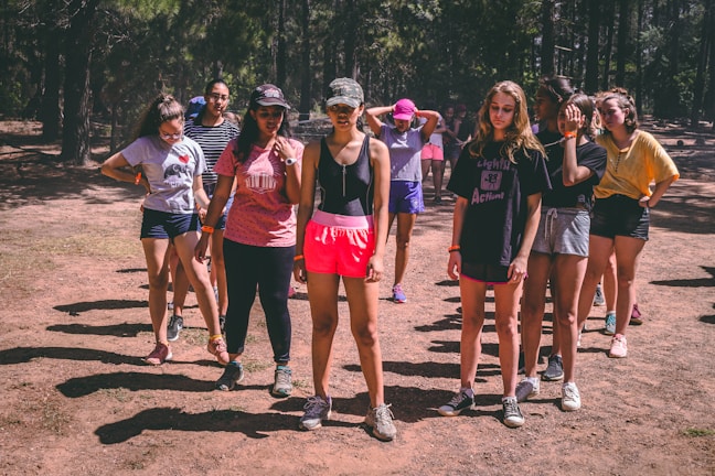 Young people planting trees together in a sunny forest clearing
