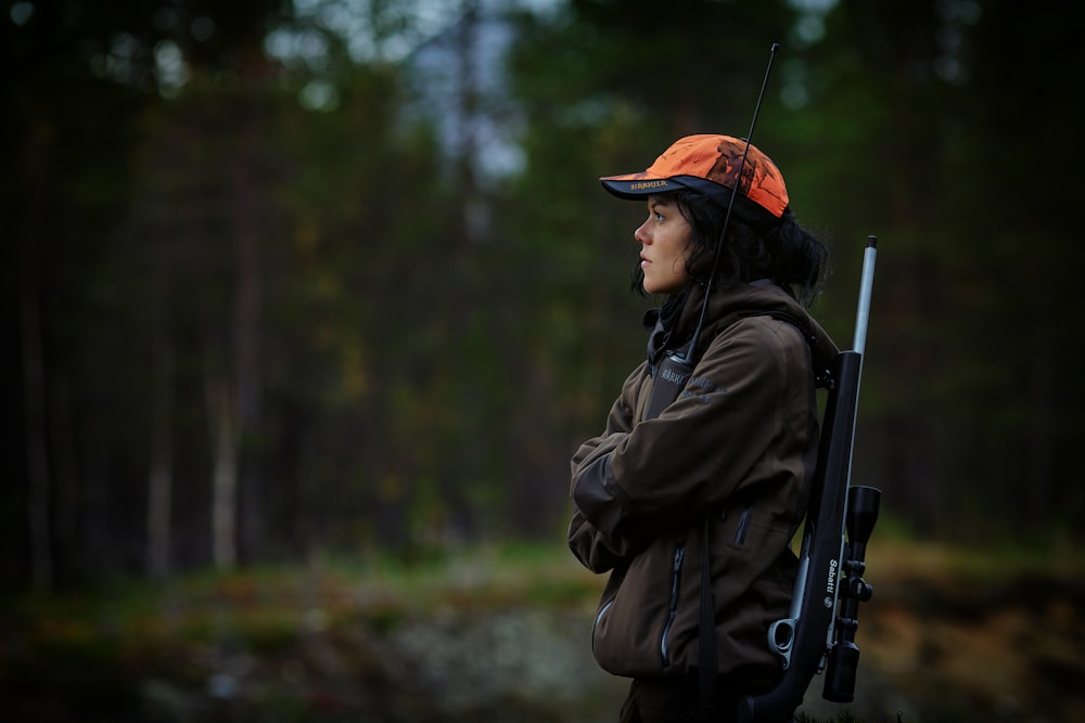 femme portant un fusil de chasse dans les bois