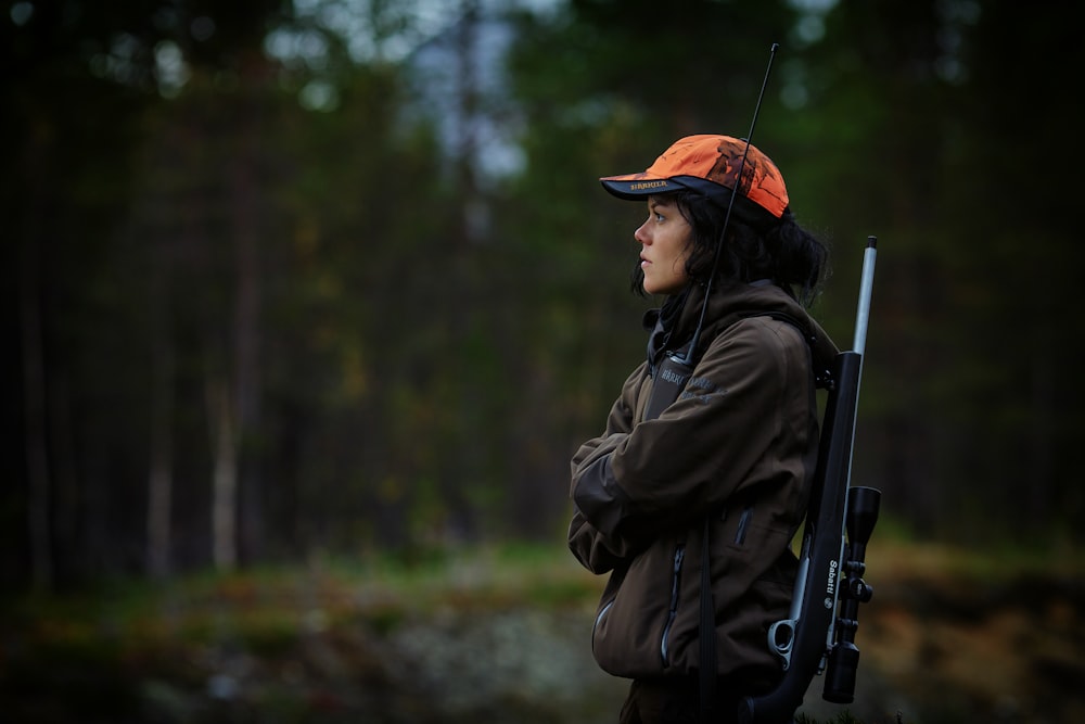 Frau trägt Jagdgewehr im Wald