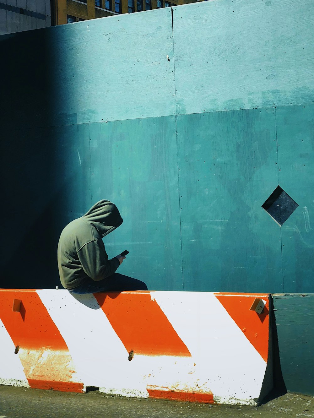 person in hooded jacket using smartphone