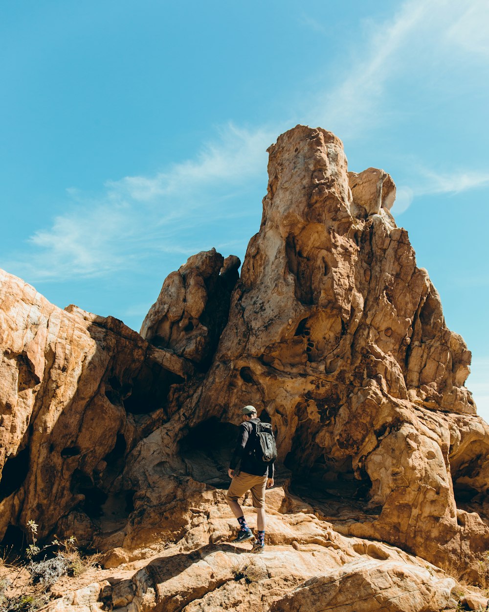 man standing in front of rock formation