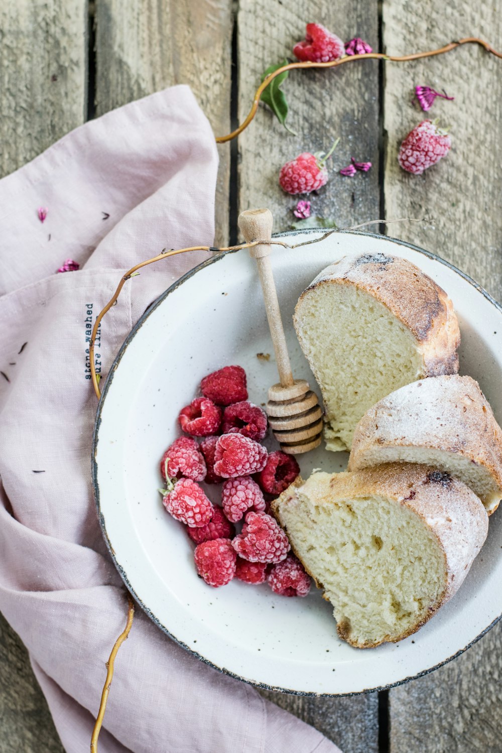 pain grillé et framboises servis sur assiette blanche