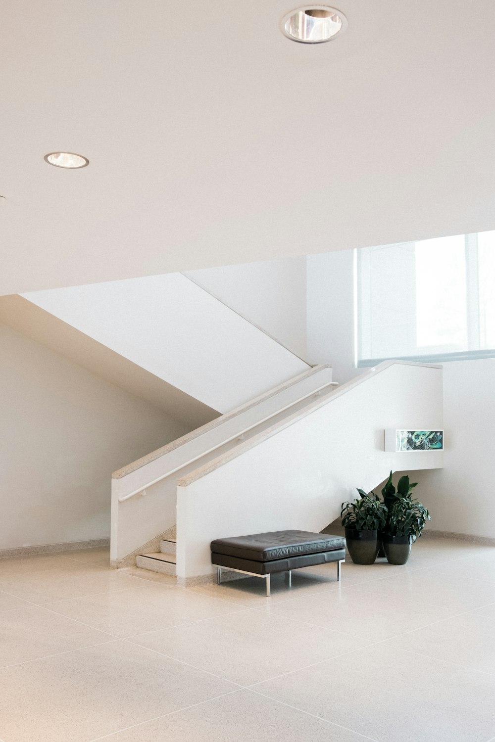 Chaise rembourrée en cuir noir devant l’escalier