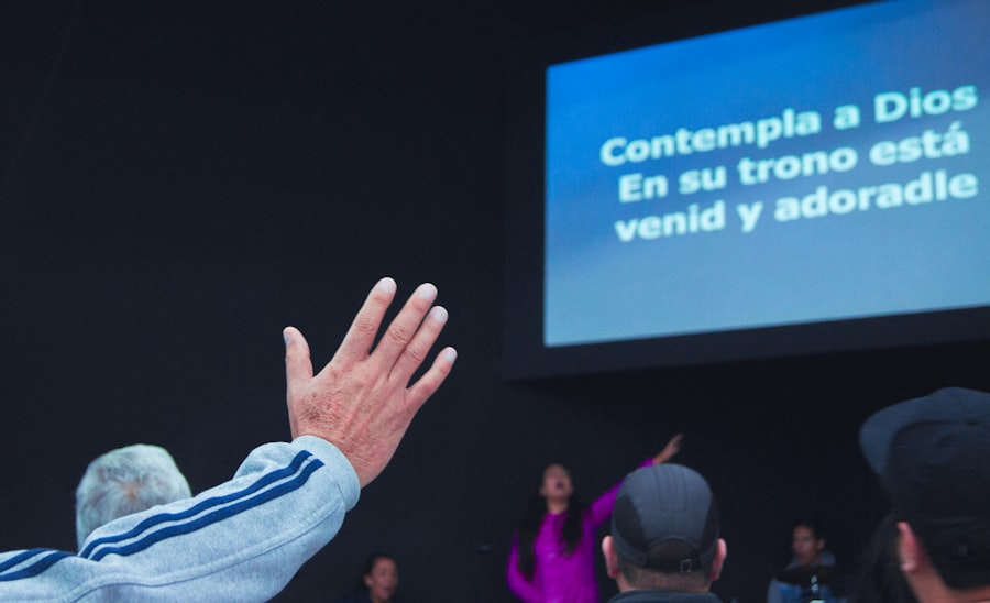 A person raises their hand and waits to ask a question at a conference meeting.