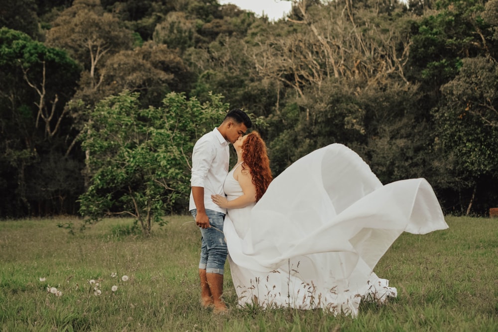 photography of kissing couple on grass field