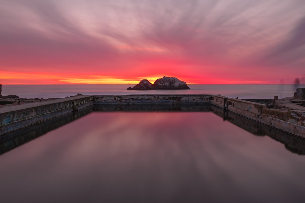 photographie de paysage de la formation rocheuse sur le plan d’eau