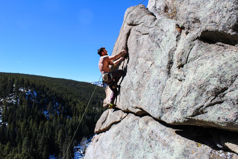 man rockclimbing at daytime