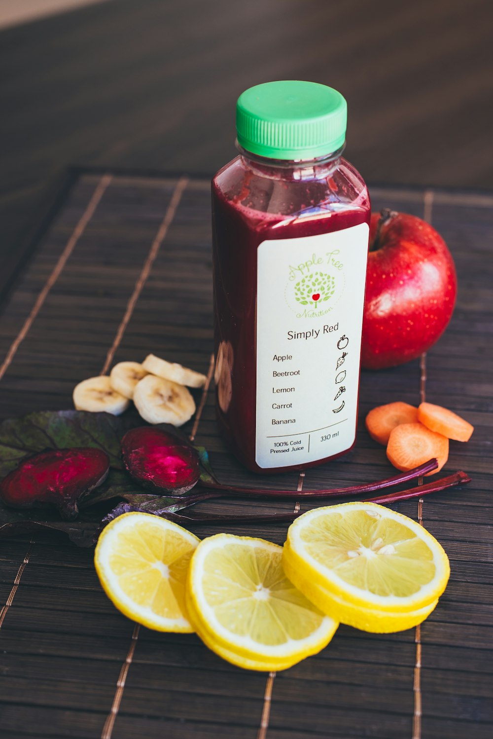 sliced lemon and red apple beside plastic bottle