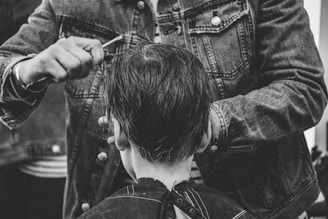 person cutting boy's hair