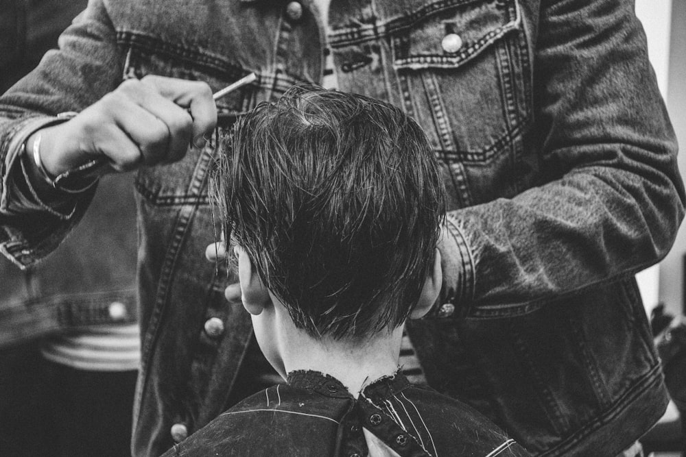 person cutting boy's hair