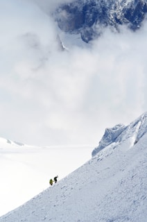 two person hiking on snow-capped mountain