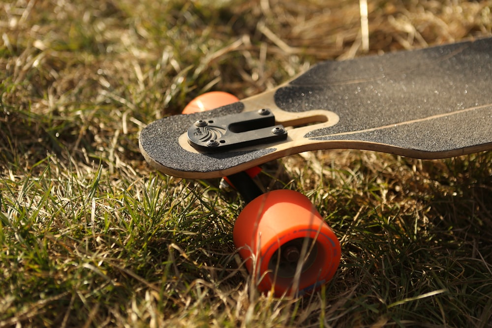 black and brown longboard on green grass at daytime