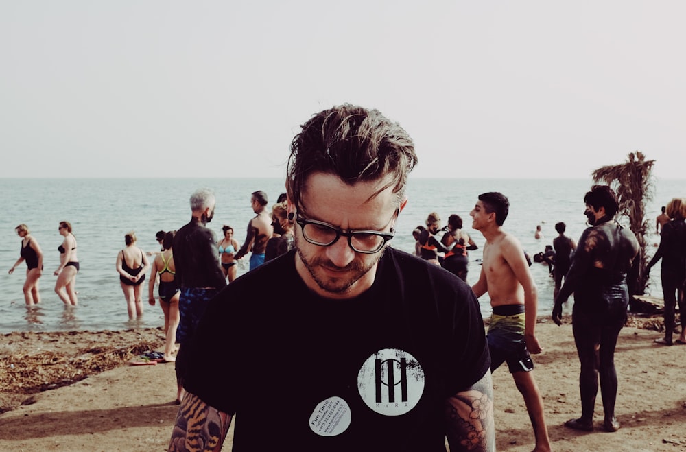 Foto de hombre con gafas de pie en la playa durante el día