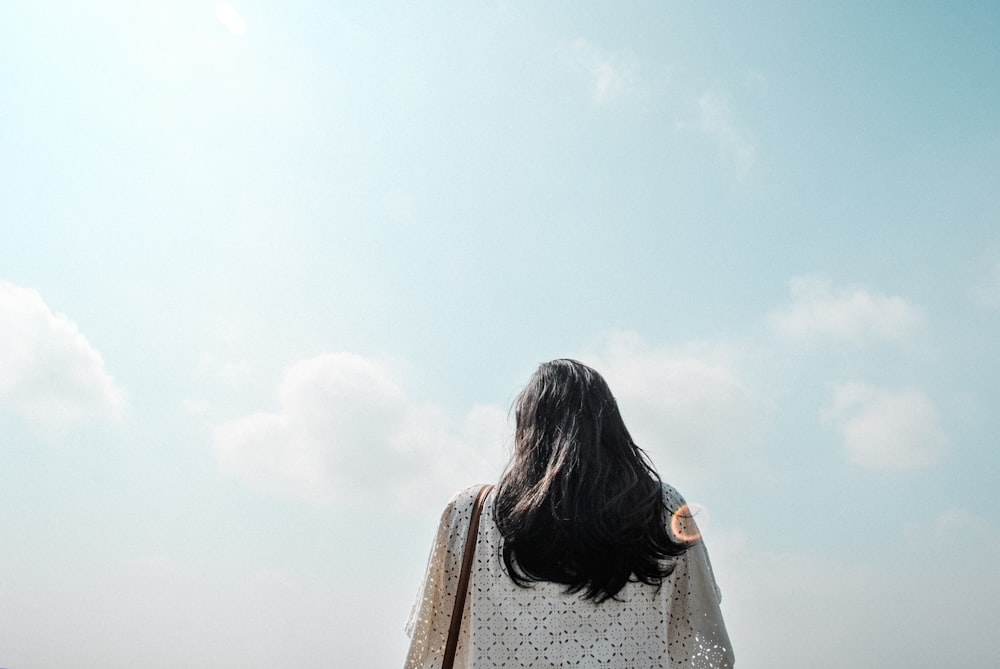 woman standing under cloudy sky during daytime