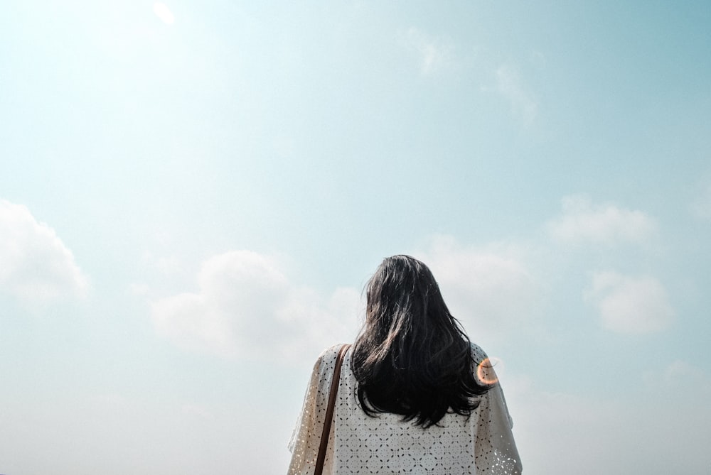 昼間の曇り空の下に立つ女性