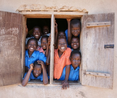 a group of young children standing in a window