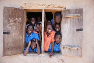a group of young children standing in a window