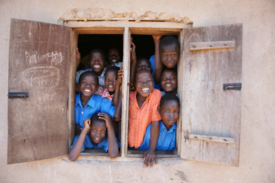 a group of young children standing in a window