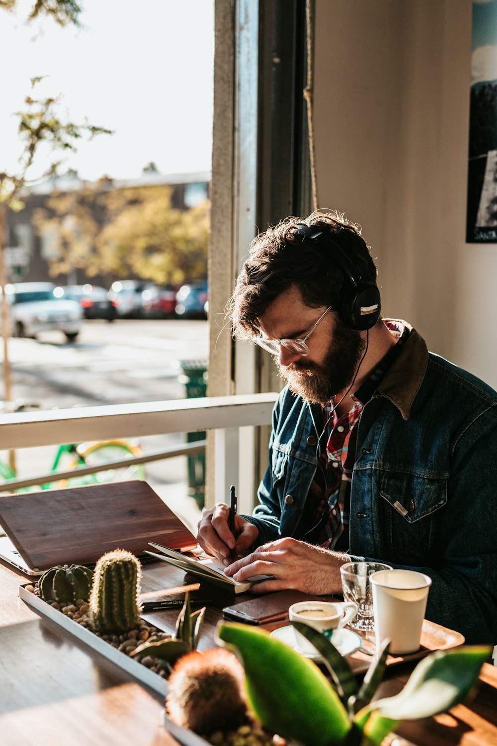 man sitting on table in front of table wriing on paper