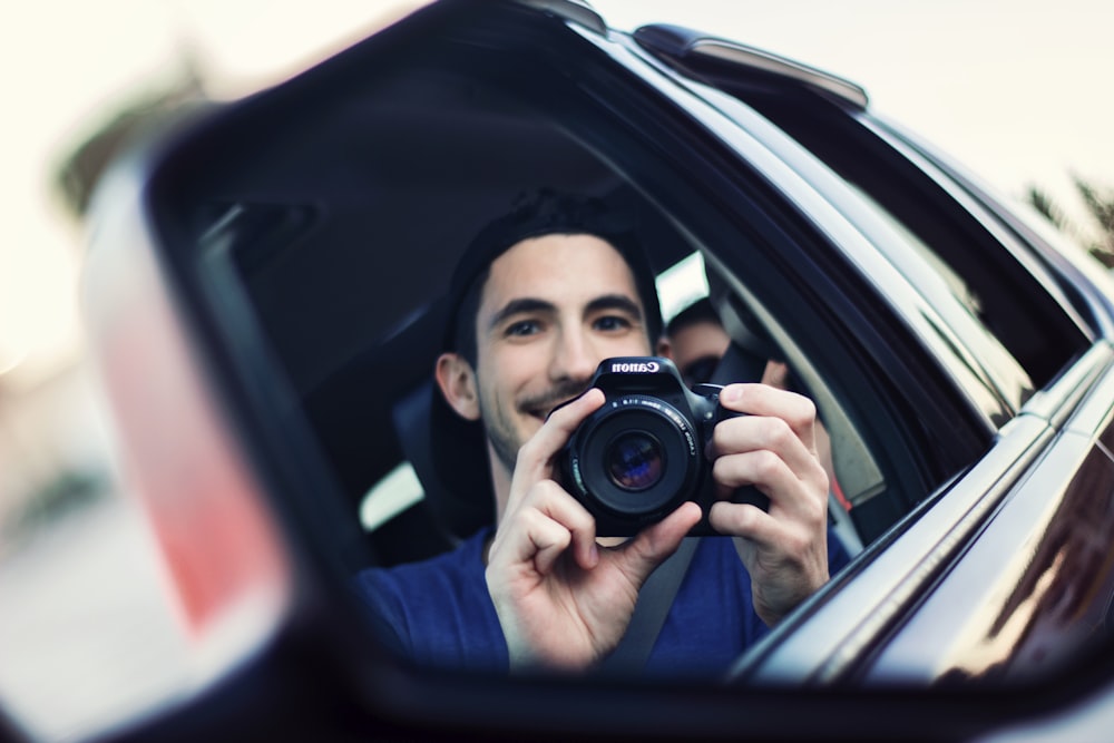 man using black DSLR camera