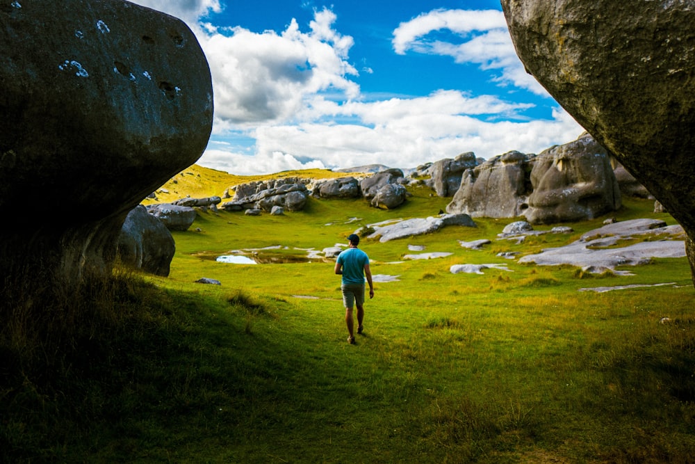 man walking on grass covered ground