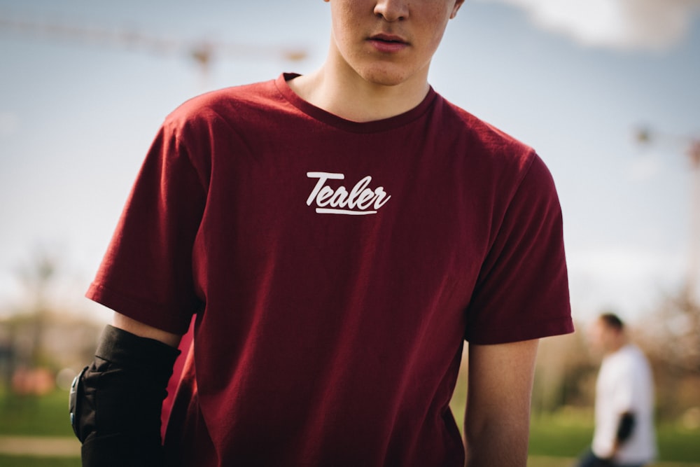 man in red crew-neck shirt under sunny sky