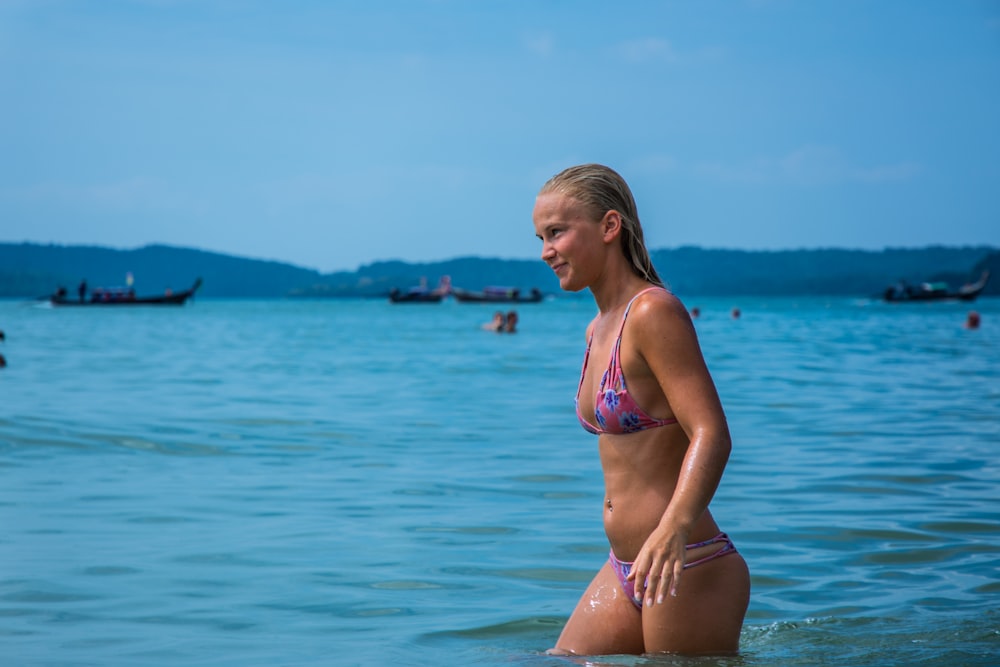 mulher no biquíni em pé na água durante o dia