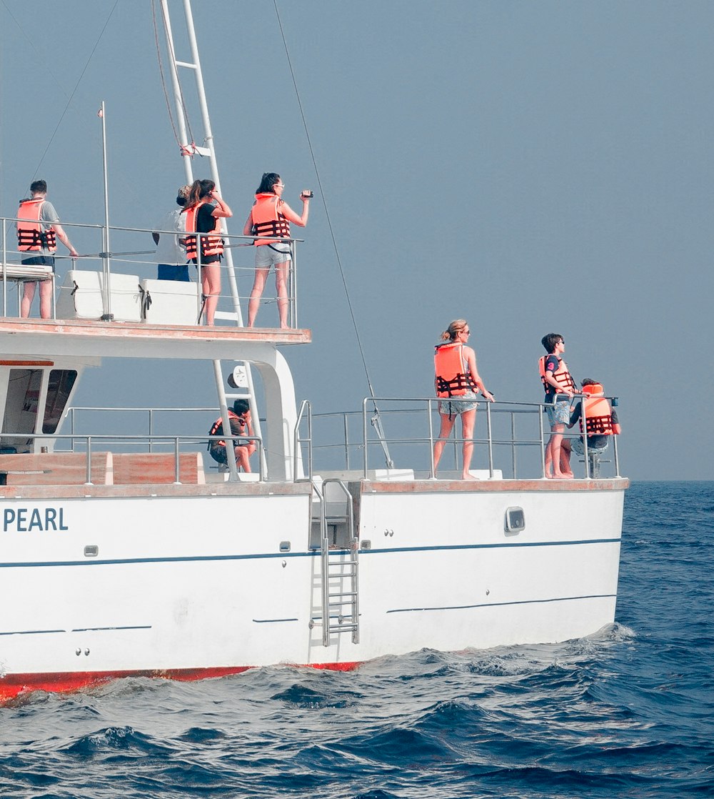 people in the yacht wearing life vest