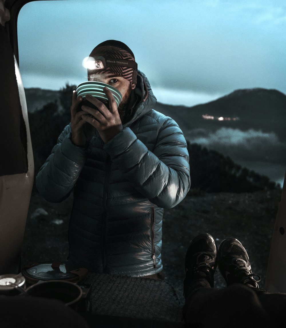 woman in black leather jacket drinking from a cup