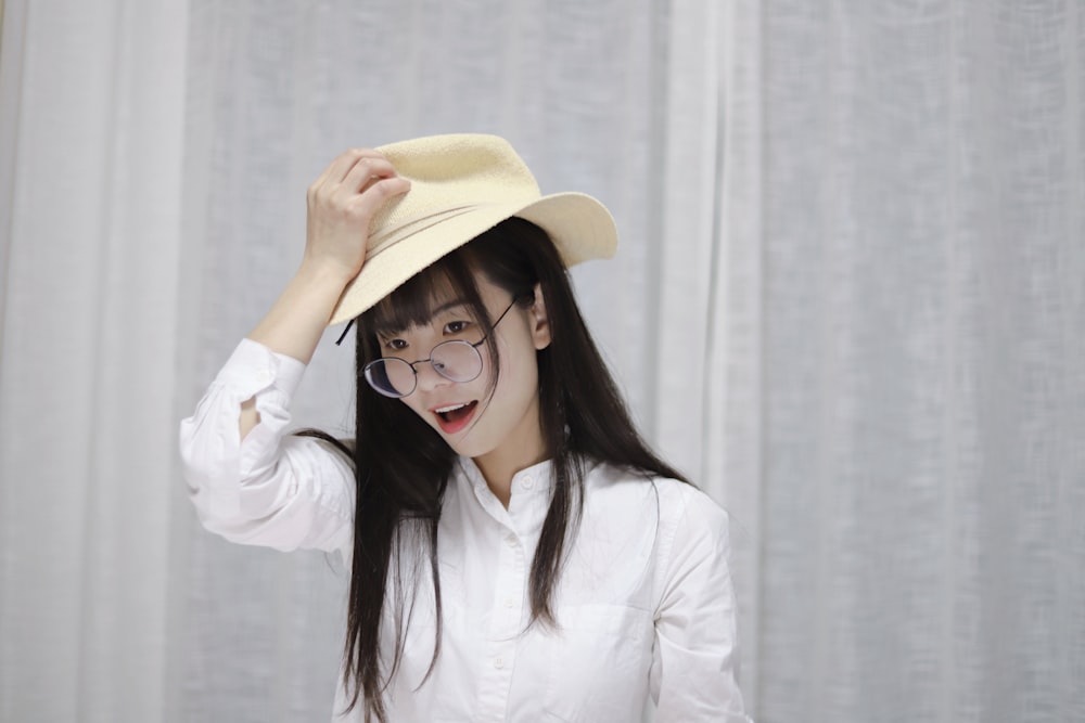 woman holding cowboy hat on head