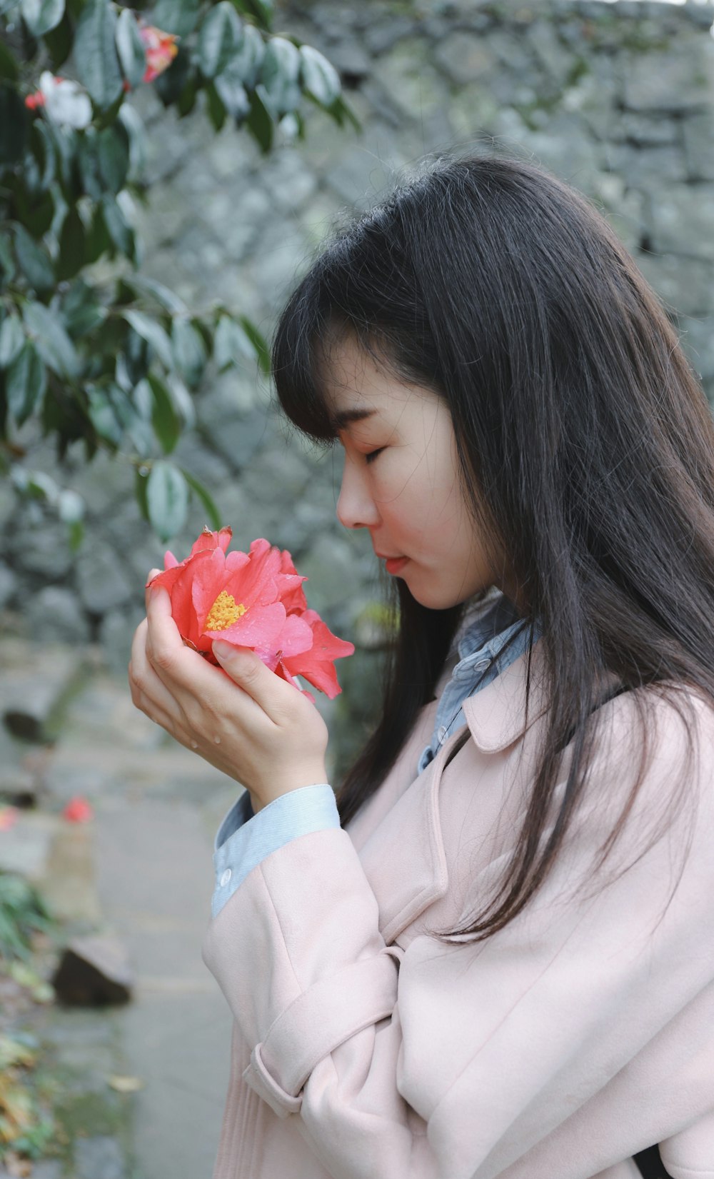 woman sniffing flower on her hands