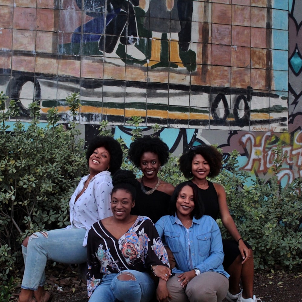 five woman sitting on the ground