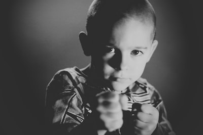 grayscale photo of boy wearing crew-neck top determined zoom background