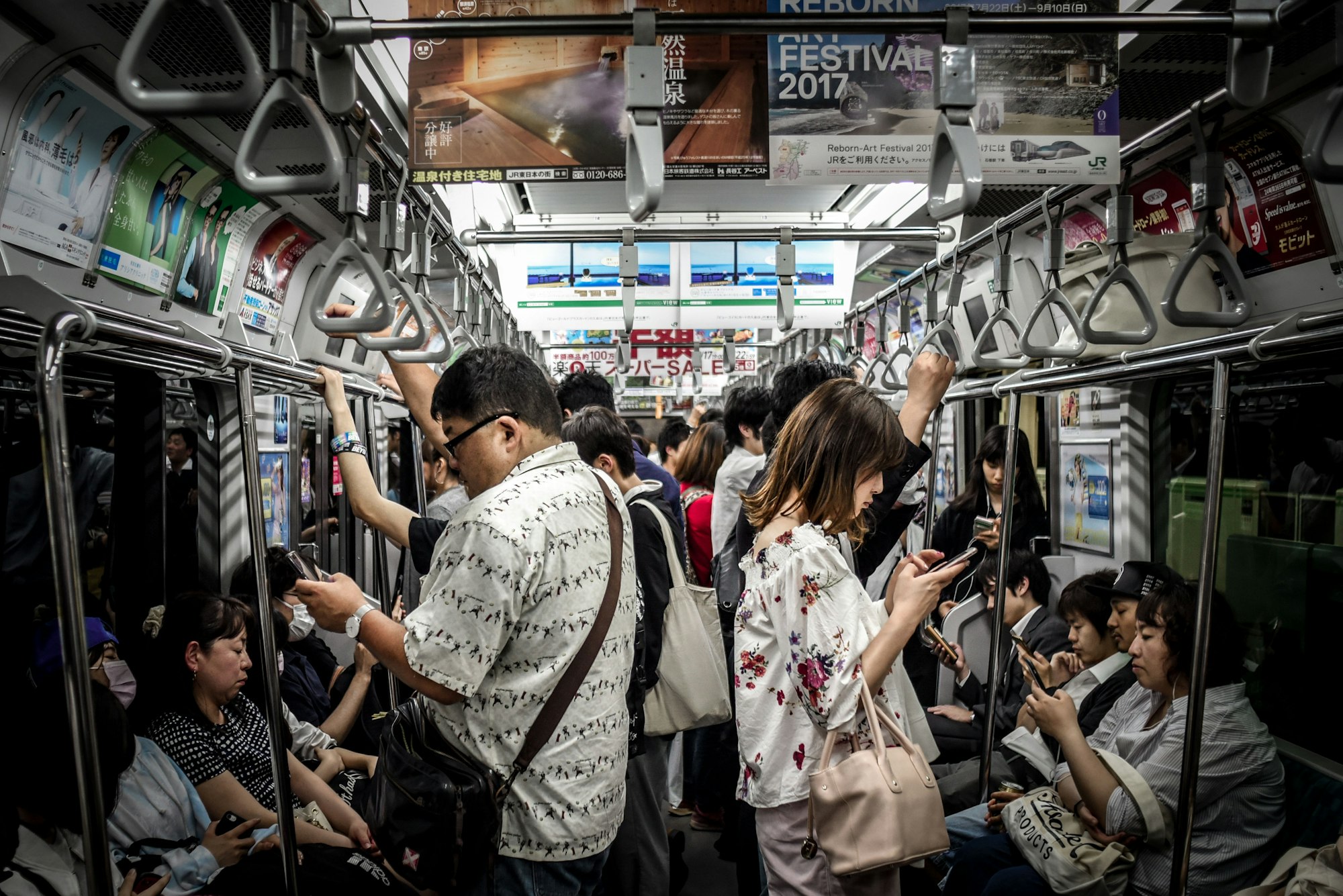 During an overnight layover in Tokyo, I decided to take the train to Shibuya to explore the area and eat some ramen. On the way back, I noticed that almost everyone one the train was anti-social and focused on their mobile devices. I took a photograph documenting this.