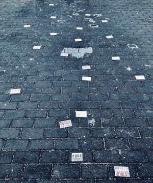 Close-up of hands arranging fragmented scripts on a cracked concrete floor.