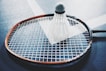 white shuttlecock on brown and black badminton racket placed on floor