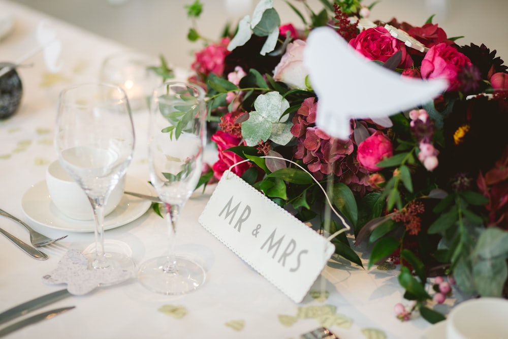 two wine glasses near flower arrangement