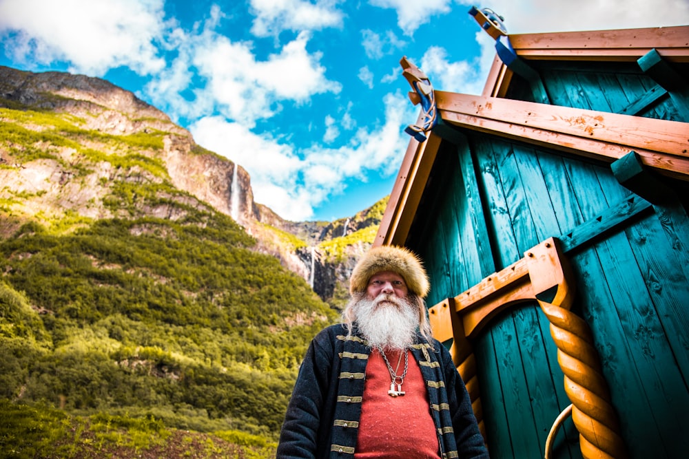 worm's eye view photography of man in front of green wooden shed