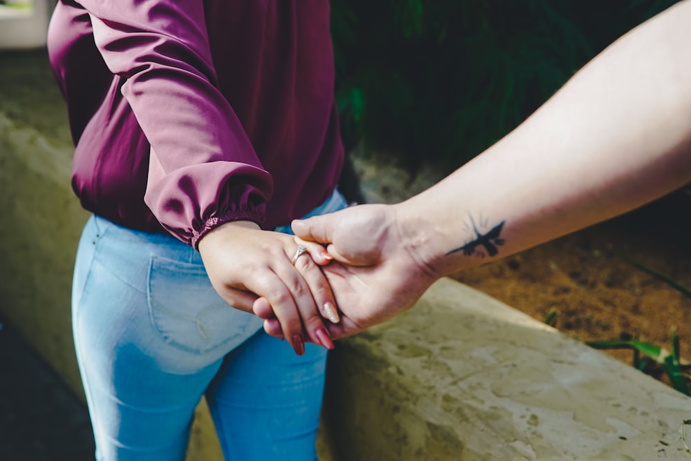 couple holding hands during daytime