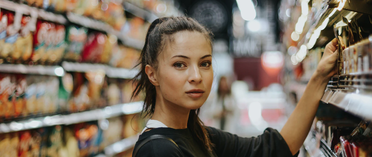 woman selecting packed food on gondola
