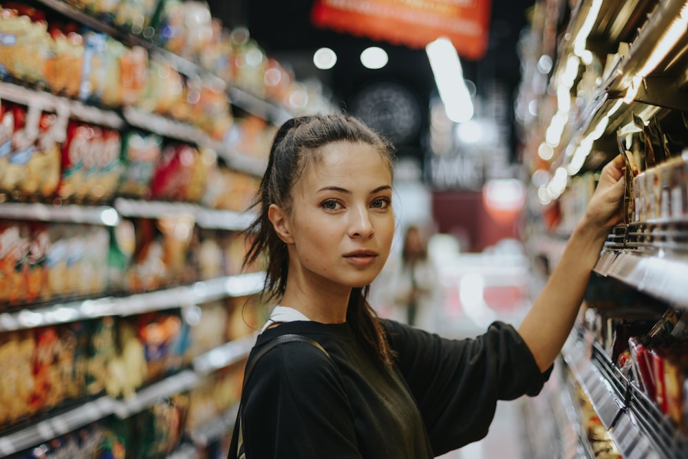 Mujer seleccionando comida envasada en góndola