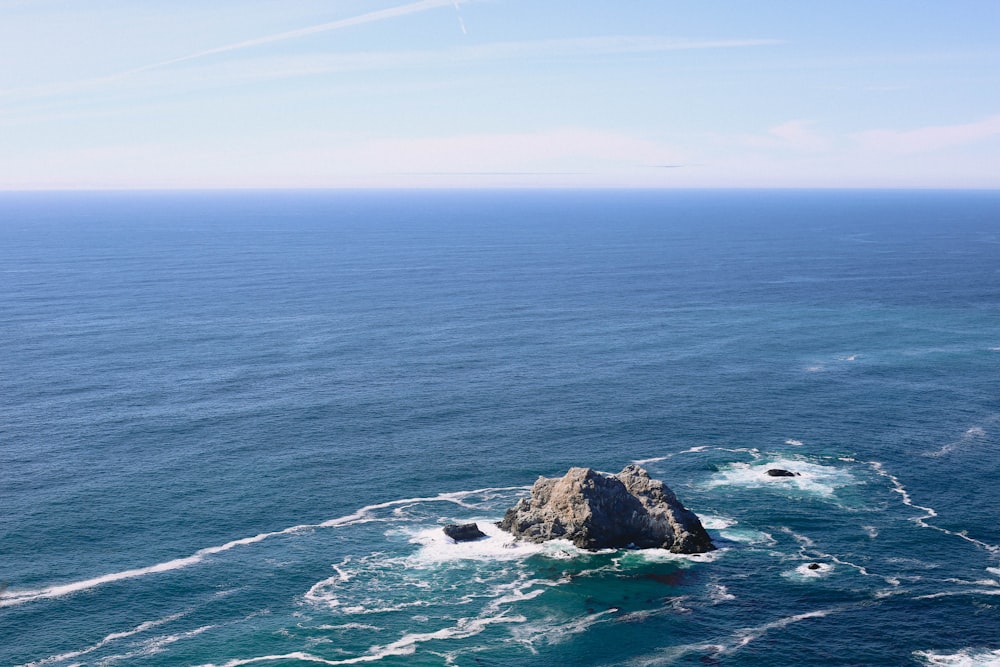 roccia circondata dall'oceano durante il giorno