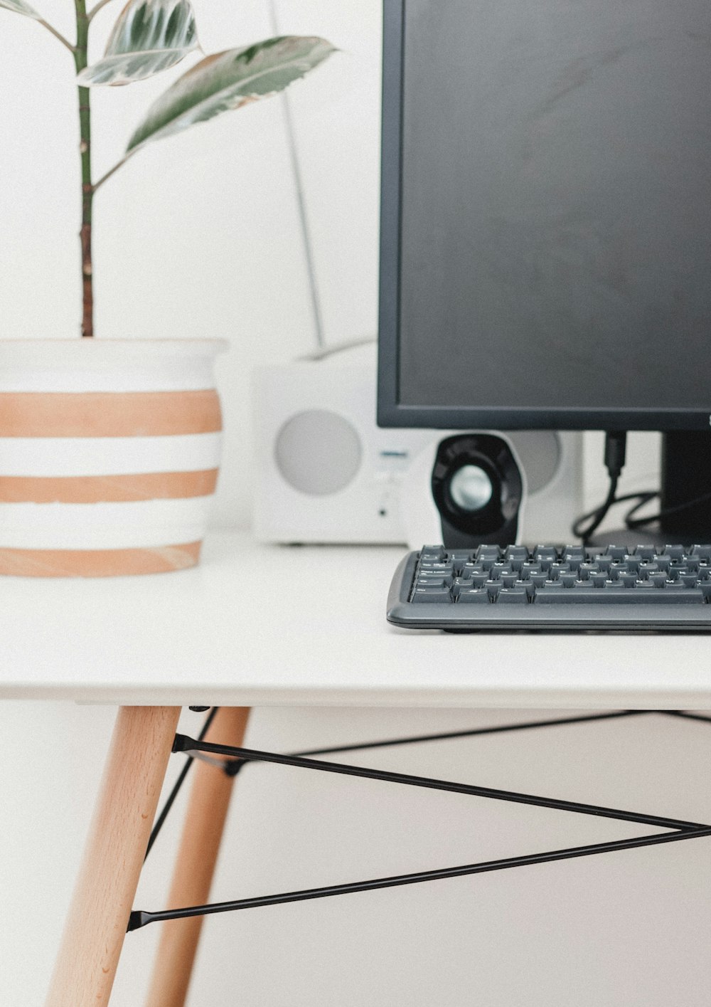 flat screen computer monitor, keyboard, and pair of speakers on wooden table